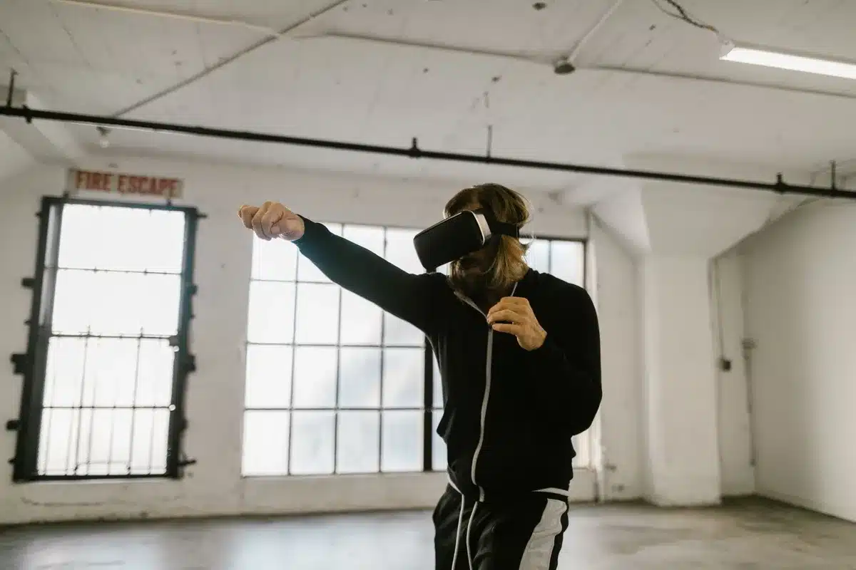 Persona che indossa un visore VR mentre si allena in palestra, immersa in un ambiente virtuale