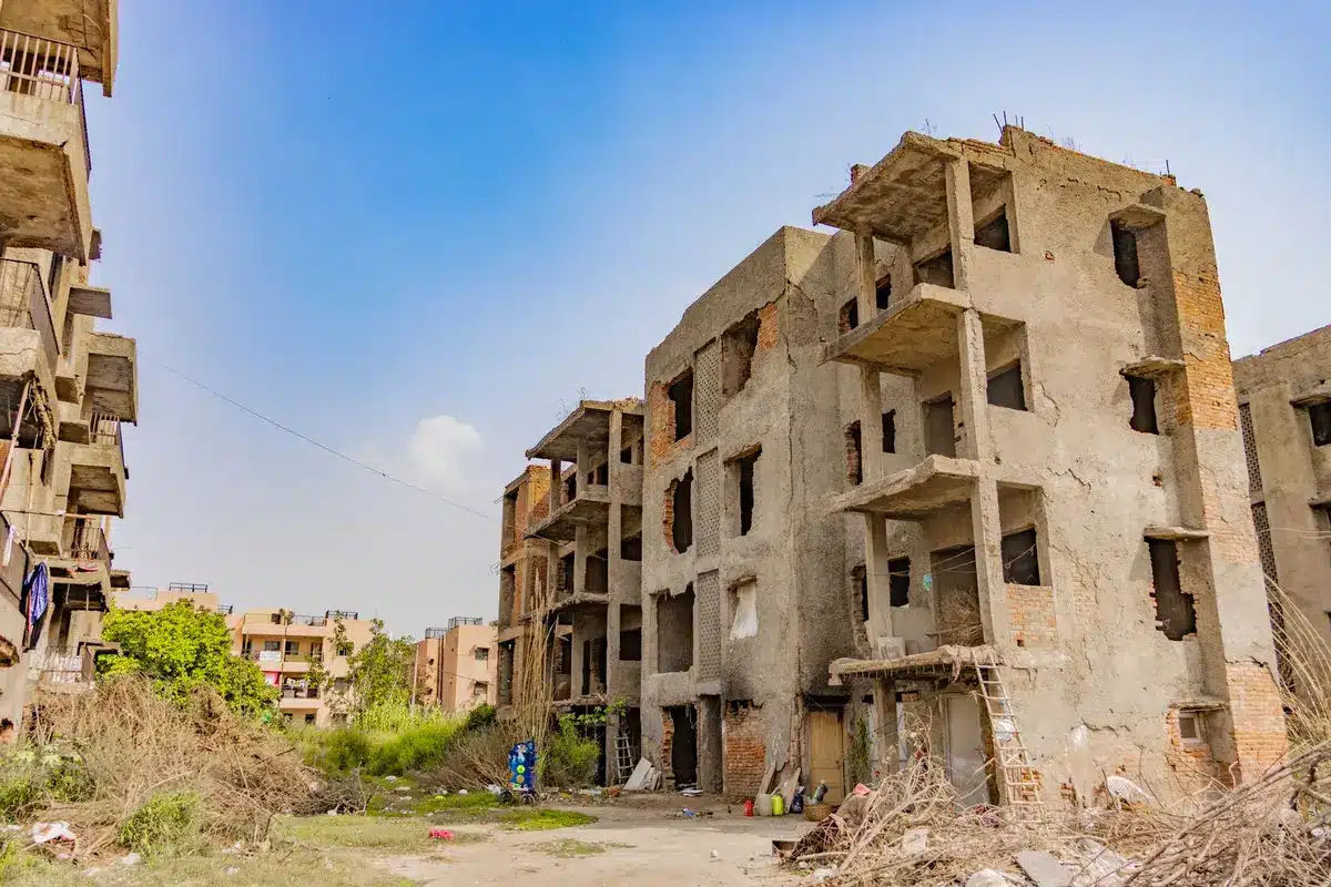 Cantiere abbandonato con edifici incompiuti e gru ferme