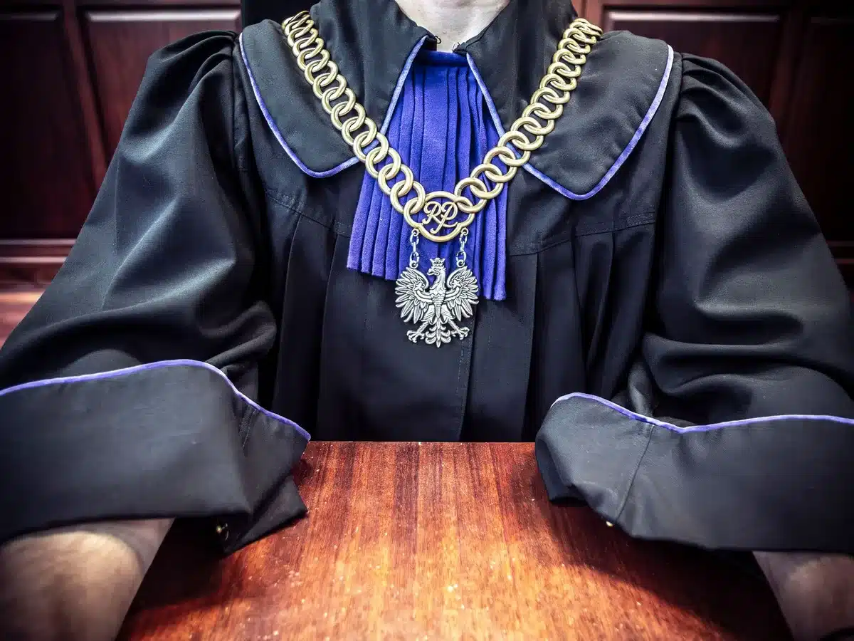 Aula di tribunale con panchina del giudice, documenti e martelletto su tavolo