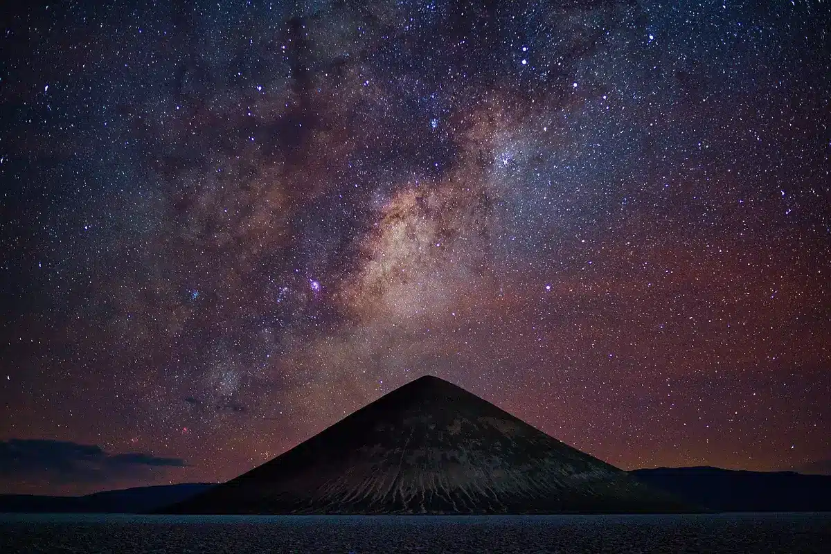 Persona che osserva il cielo notturno con un telescopio, scoprendo le meraviglie dell'universo.