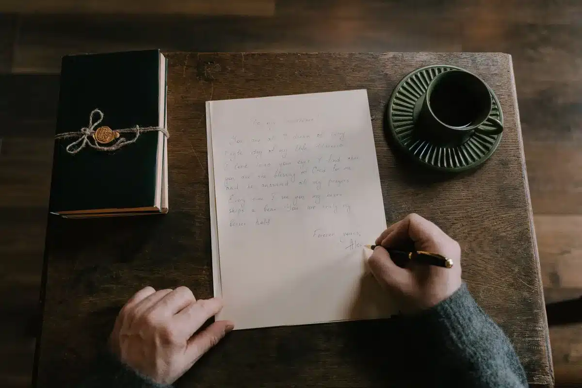 Scrivania con diari aperti, pagine manoscritte e penna sotto luce calda