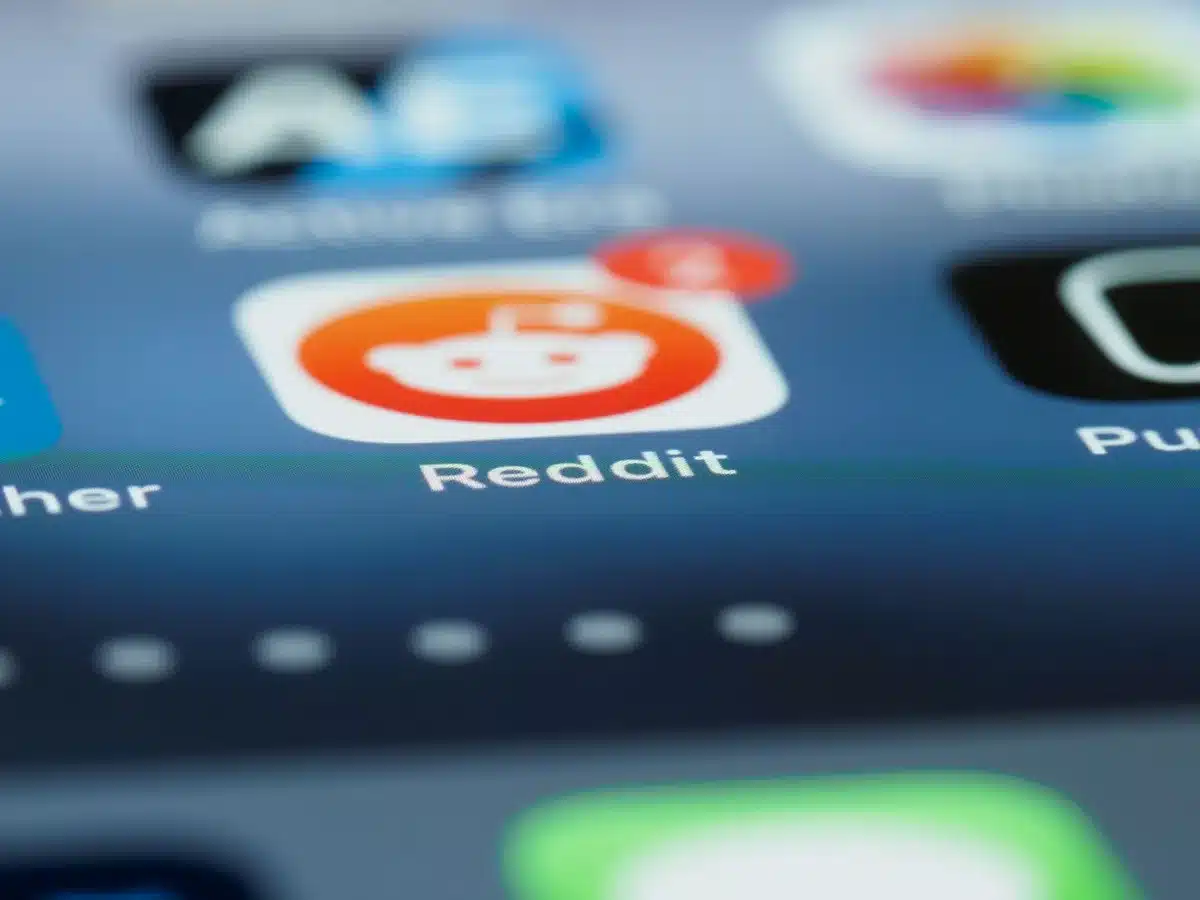 Mani che tengono uno smartphone con icone colorate di app e notifiche sullo schermo