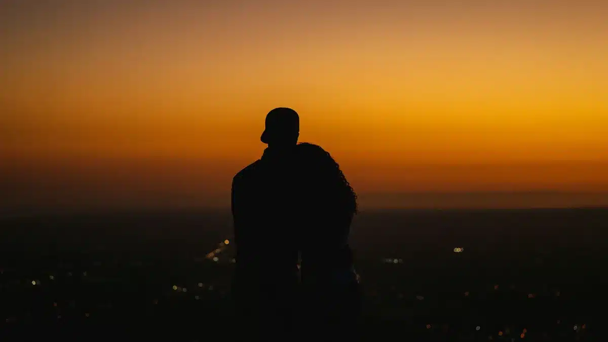 Coppia che si abbraccia sotto la luce del tramonto, momento romantico e intimo