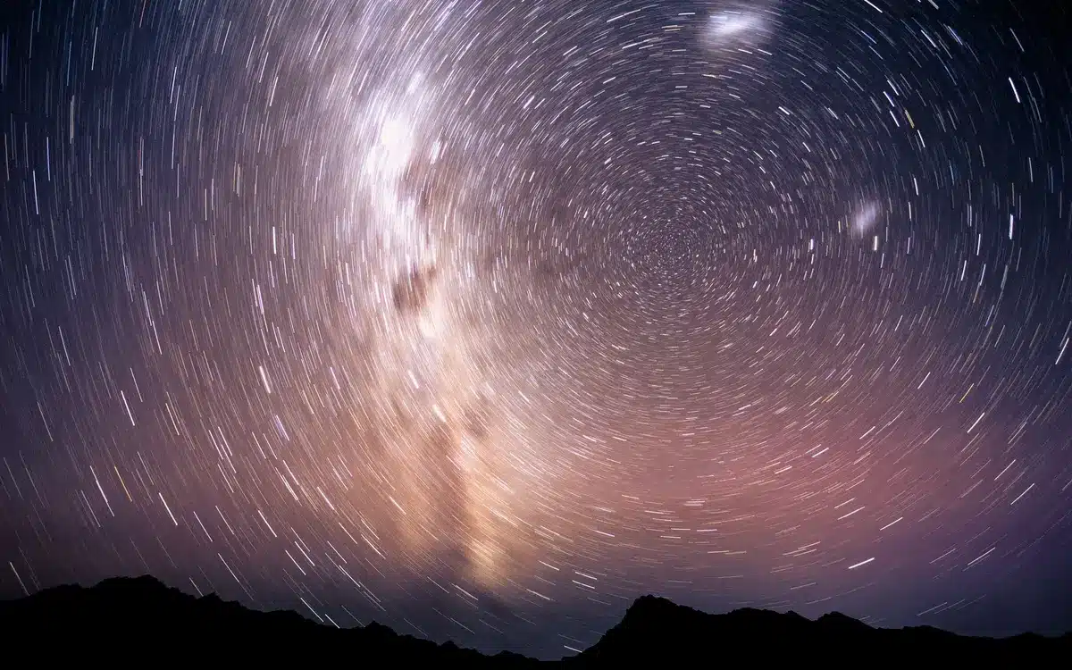 Ruota dello zodiaco con simboli zodiacali che brillano sotto il cielo stellato notturno