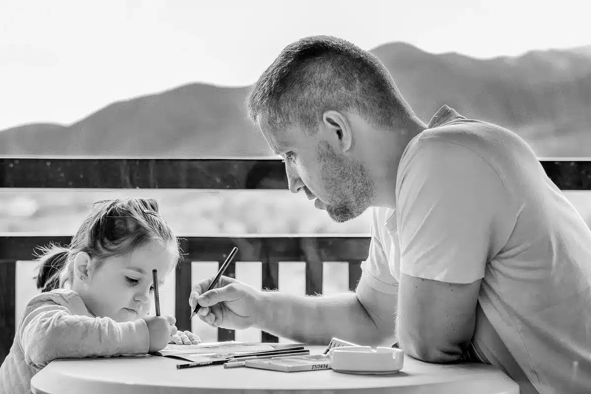 Padre e figlia condividono momenti insieme raccogliendo carte da collezione come attività familiare.