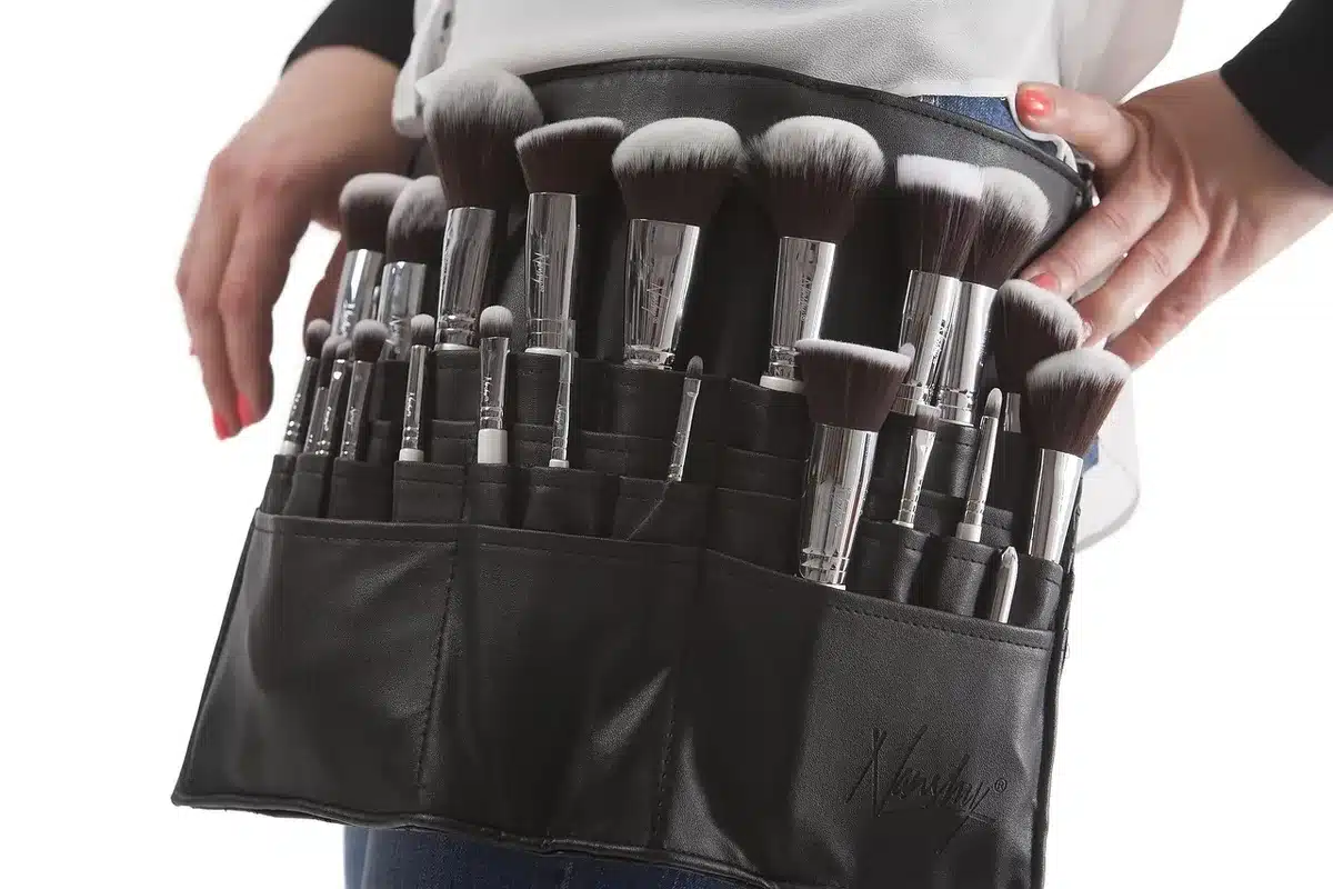 Flacone di primer trucco su vanity con pennelli e specchio illuminato