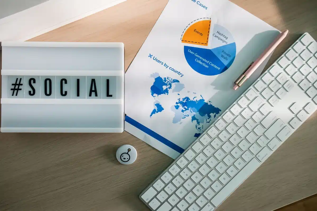 Mani che tengono uno smartphone con icone di social media e metriche di engagement sullo schermo