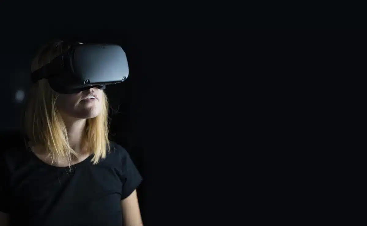 Persona che indossa visore di realtà virtuale in ambiente immersivo