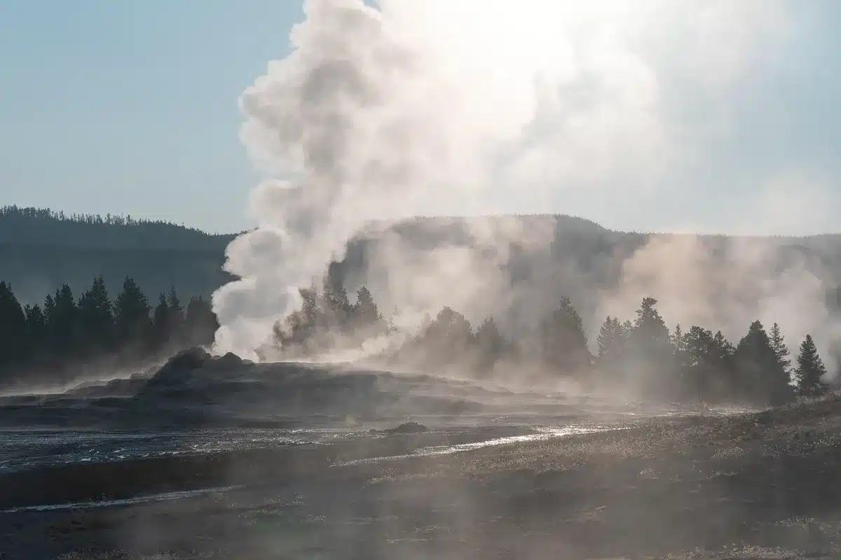 Geyser in eruzione con visitatori a distanza osservano in sicurezza
