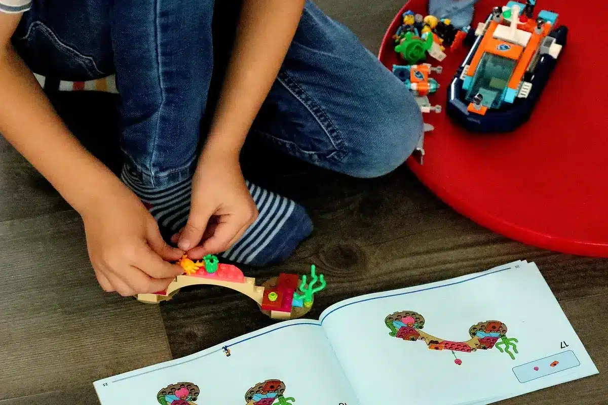 Bambini e appassionati partecipano a un workshop LEGO vicino a un circuito