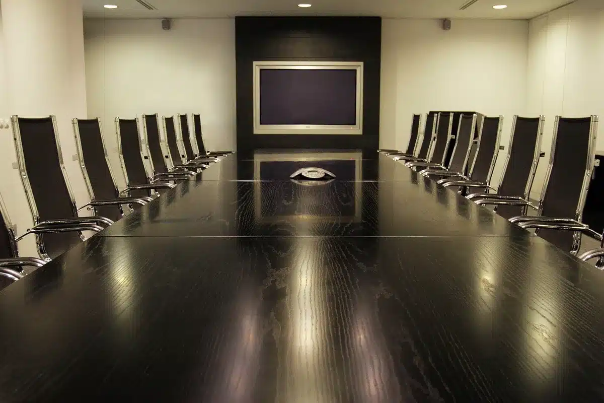 Sala riunioni con documenti e mani che discutono decisioni aziendali