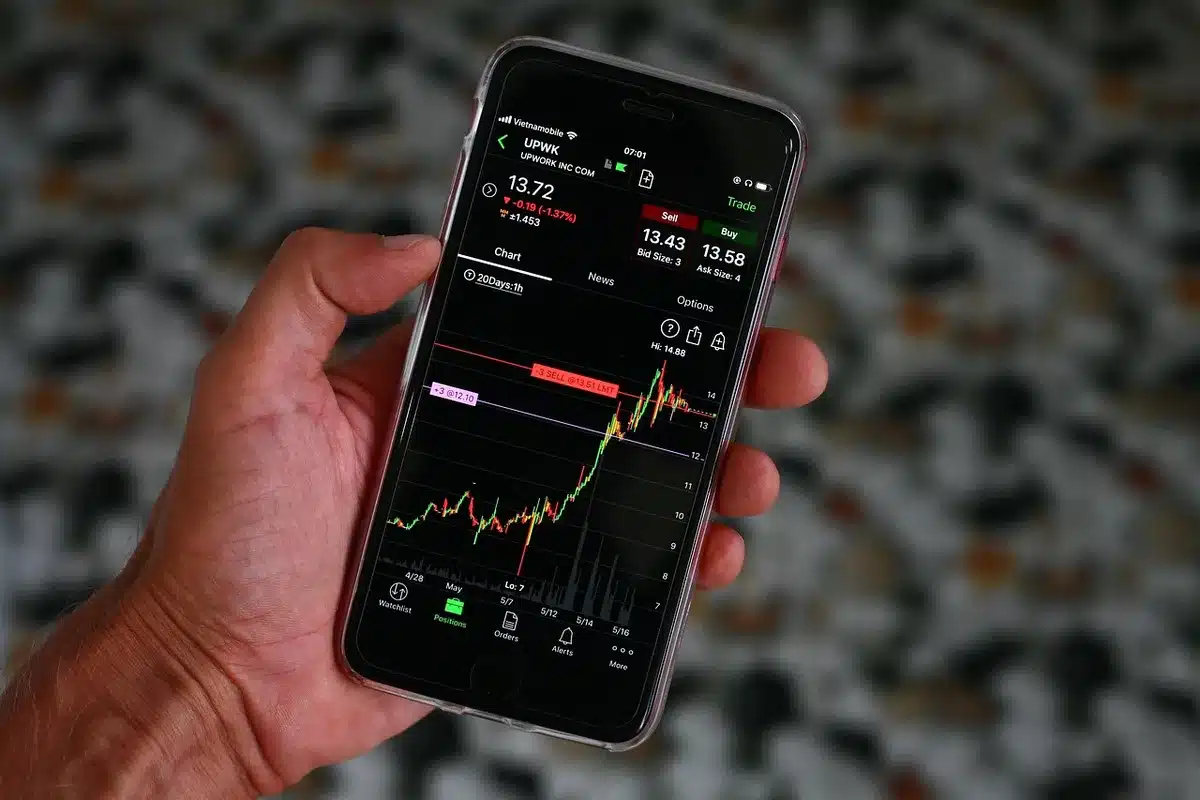 Operatori finanziari al lavoro su schermi di dati di borsa e grafici di mercato in una sala trading