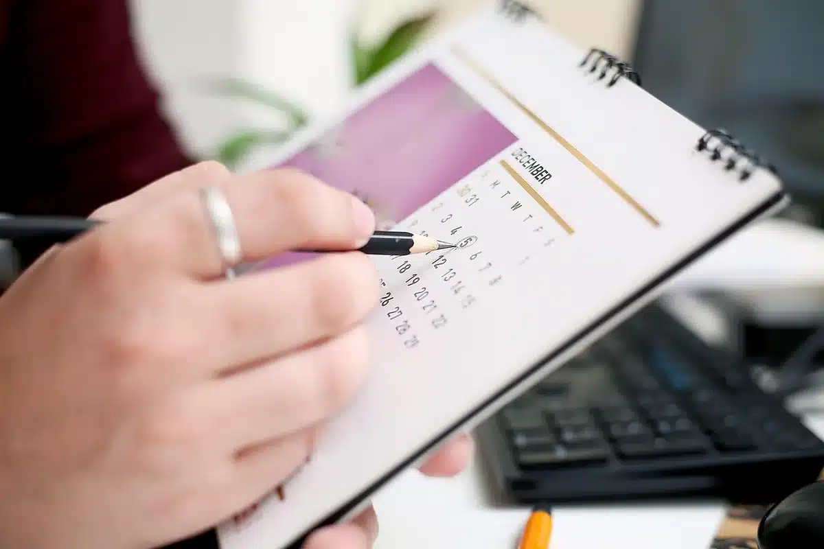 Scrivania con calendario, orologio e post‑it colorati che segnano blocchi di lavoro