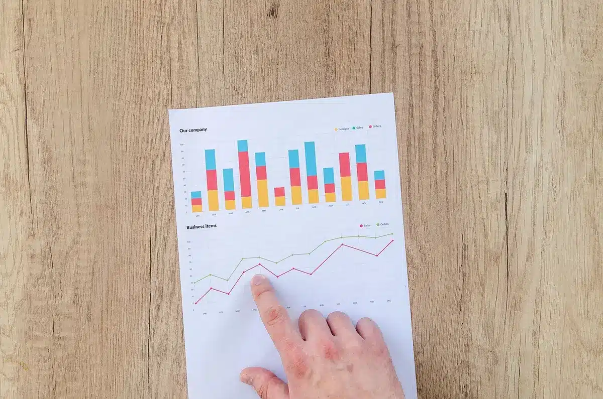Mani anonime che consultano grafici finanziari e documenti di debito su una scrivania
