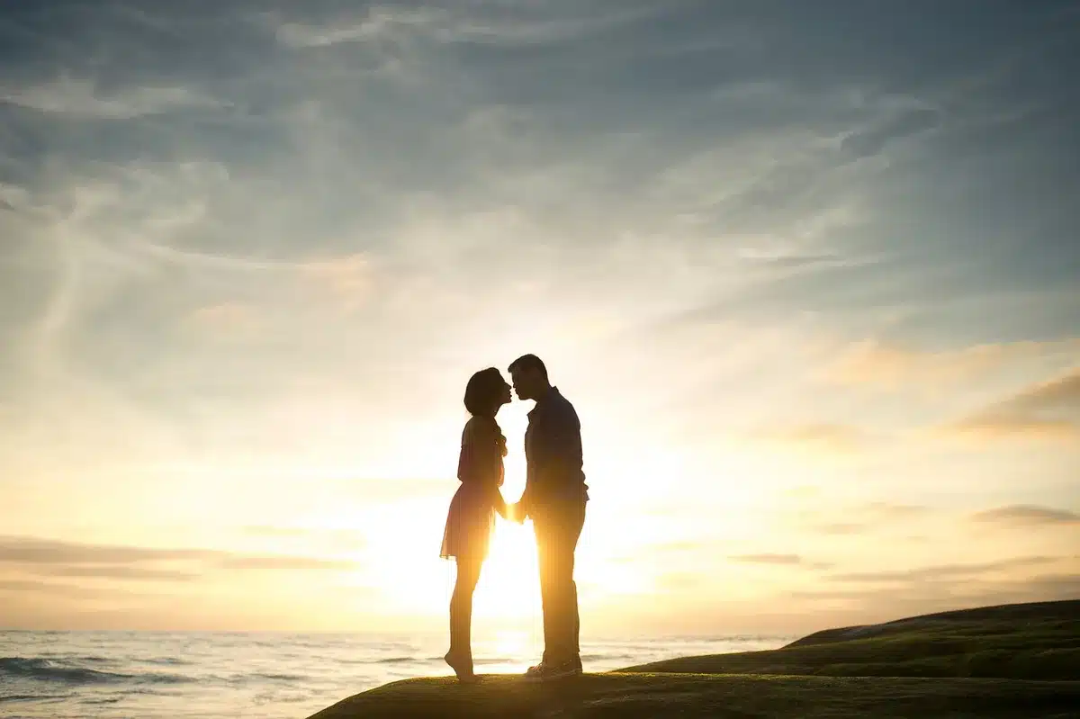 Coppia che si tiene per mano al tramonto, silhouette romantica