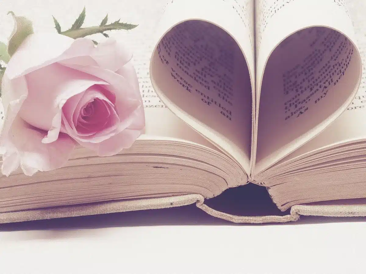 Scrivania d'epoca con libri di fisica, appunti e una bussola vintage alla luce del giorno