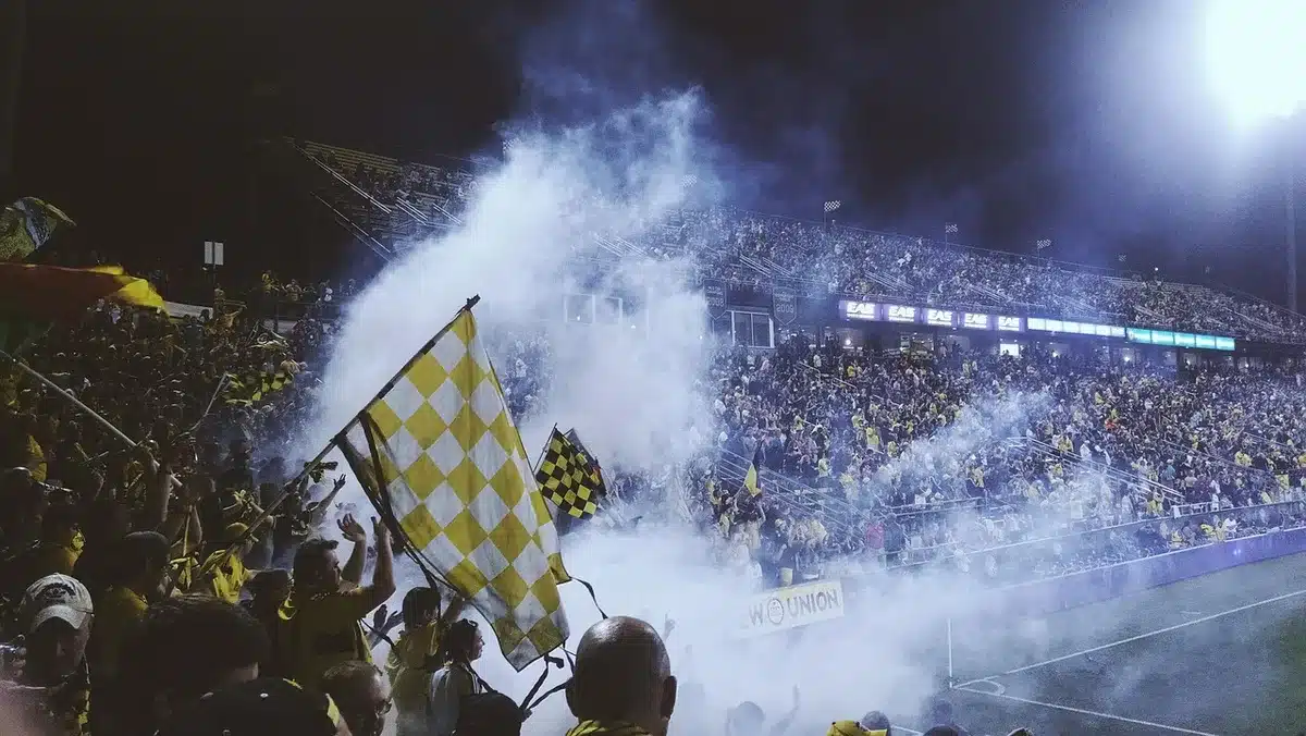 Tifosi anonimi in silhouette davanti a uno stadio di sera