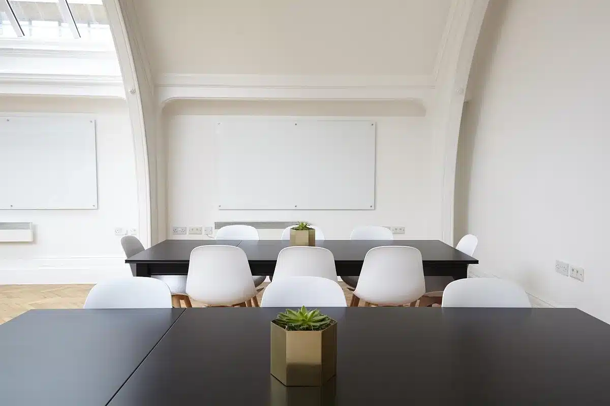 Sala conferenze con laptop e lavagna con grafici, simbolo di strategia e analisi