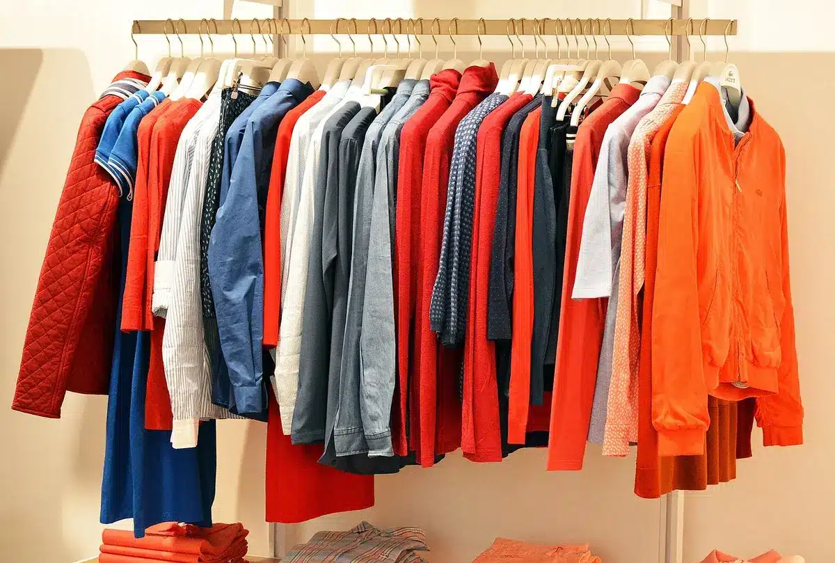 Interno di boutique di moda maschile con abiti su manichino e tavolo espositivo