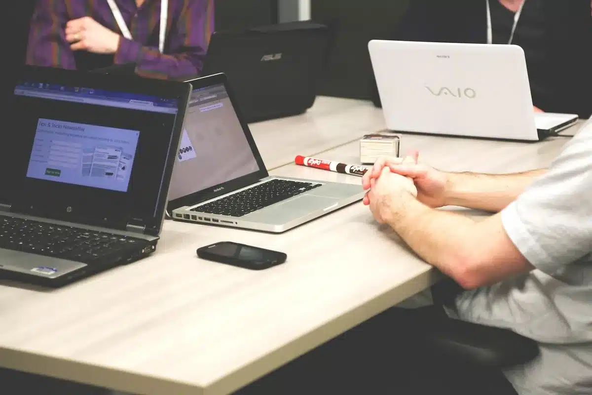 Accademici e manager a un tavolo di confronto, appunti e computer sul tavolo