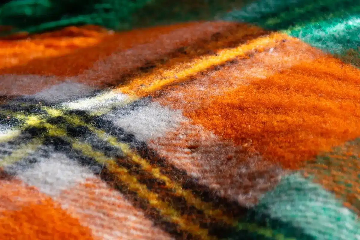 Angolo lettura con cuscini, coperta e una tazza di tè