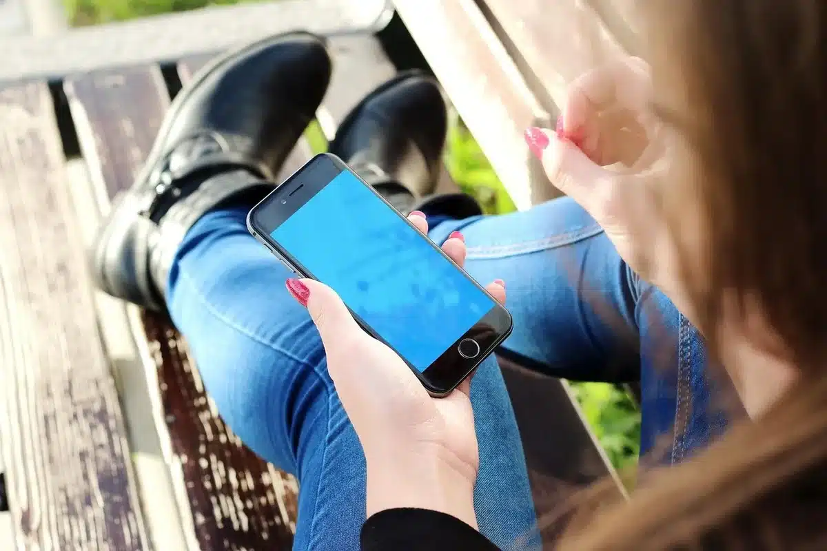 Persona anonima con biglietto della lotteria e smartphone su un bancone di ricevitoria