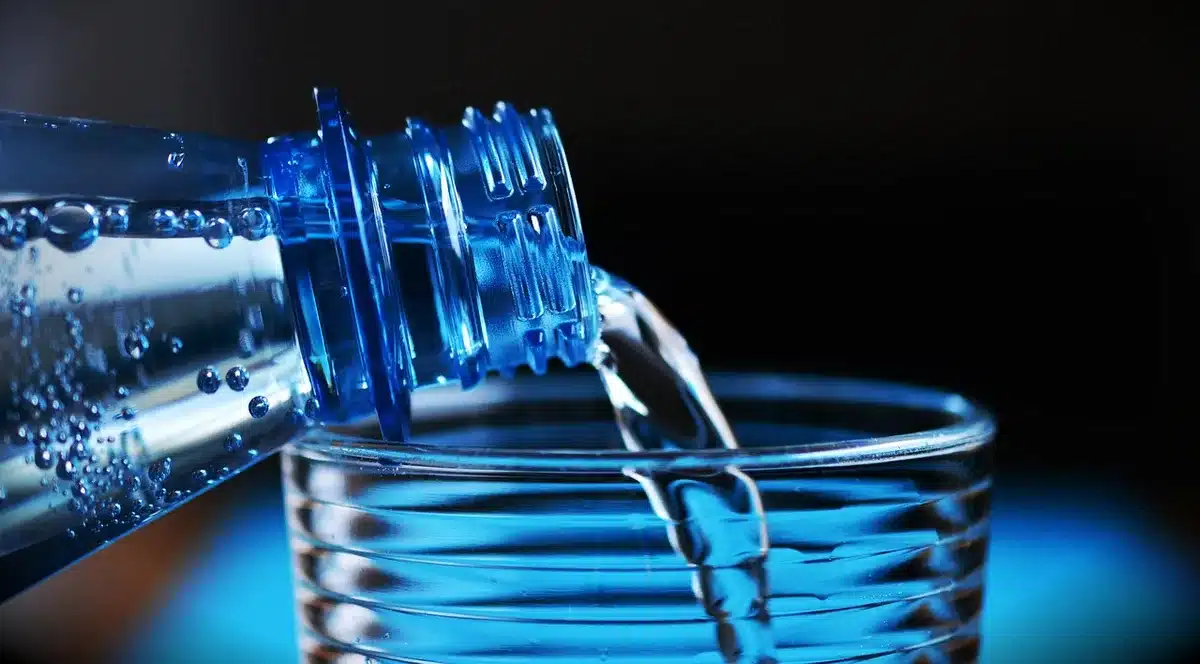 Persona che beve acqua durante l'esercizio per idratazione