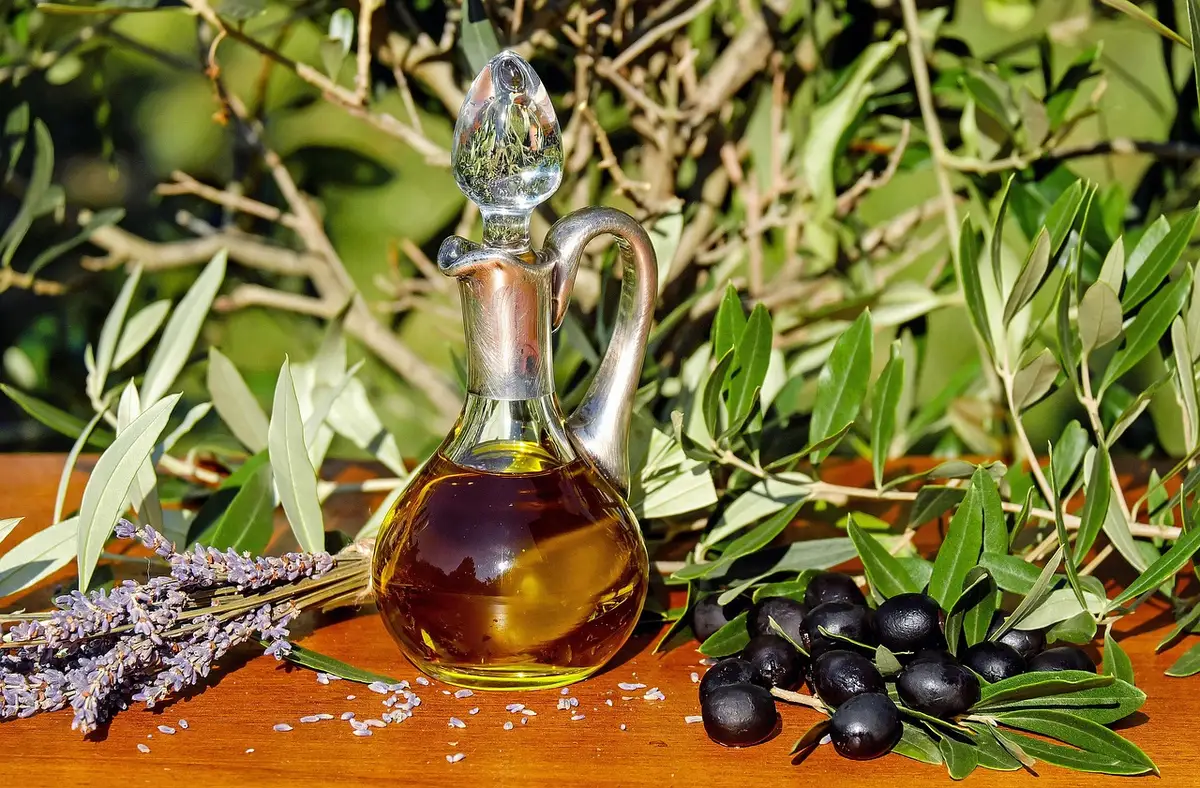 Bicchiere d'acqua e caraffa su tavolo con pianta sfocata sullo sfondo