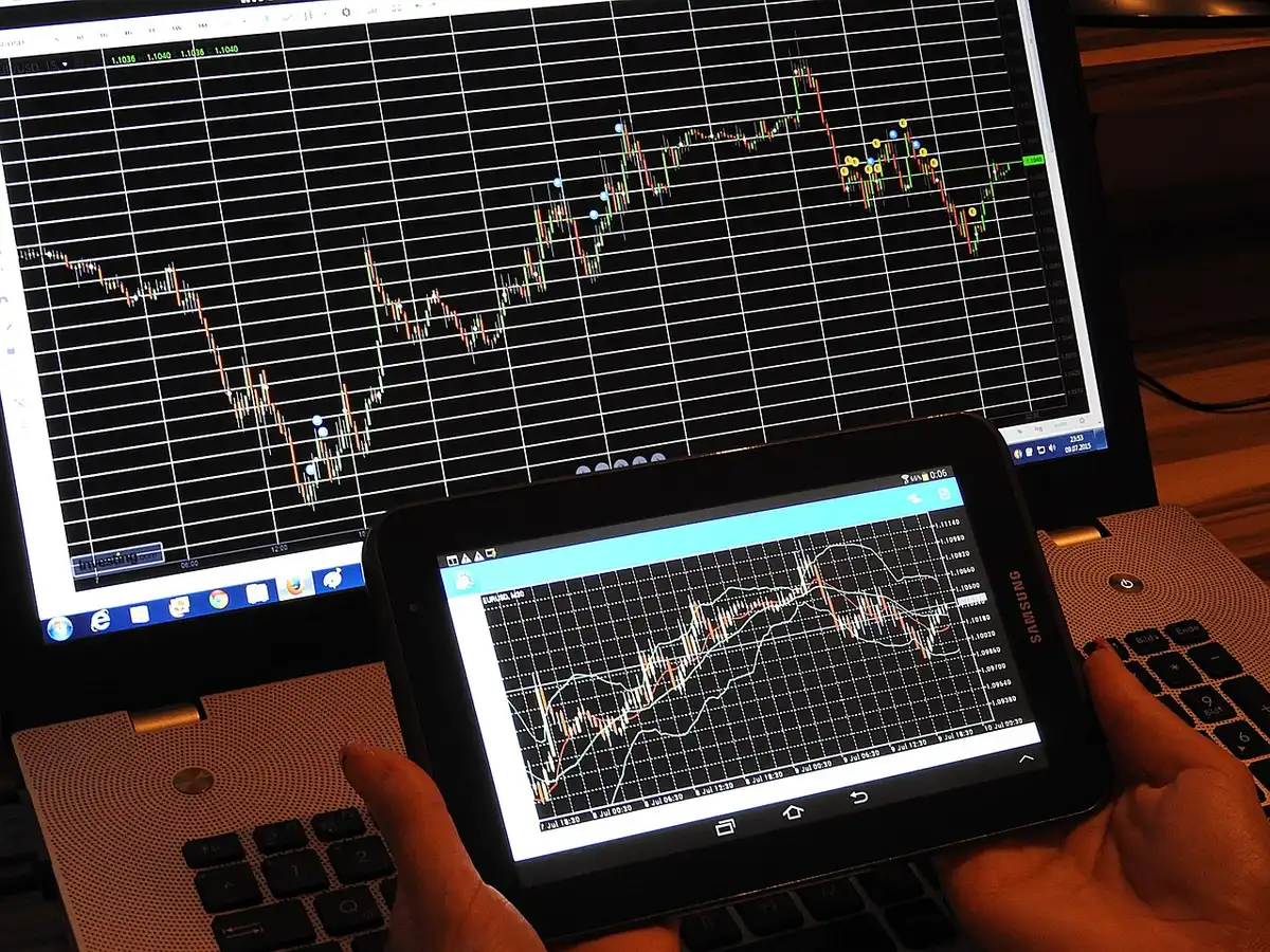 Grafico finanziario su schermo con frecce e cifre, rappresenta tensione sul mercato