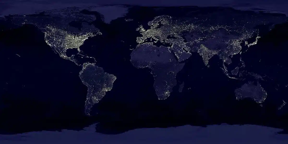 Mappa geopolitica su un tavolo con mani anonime che indicano regioni