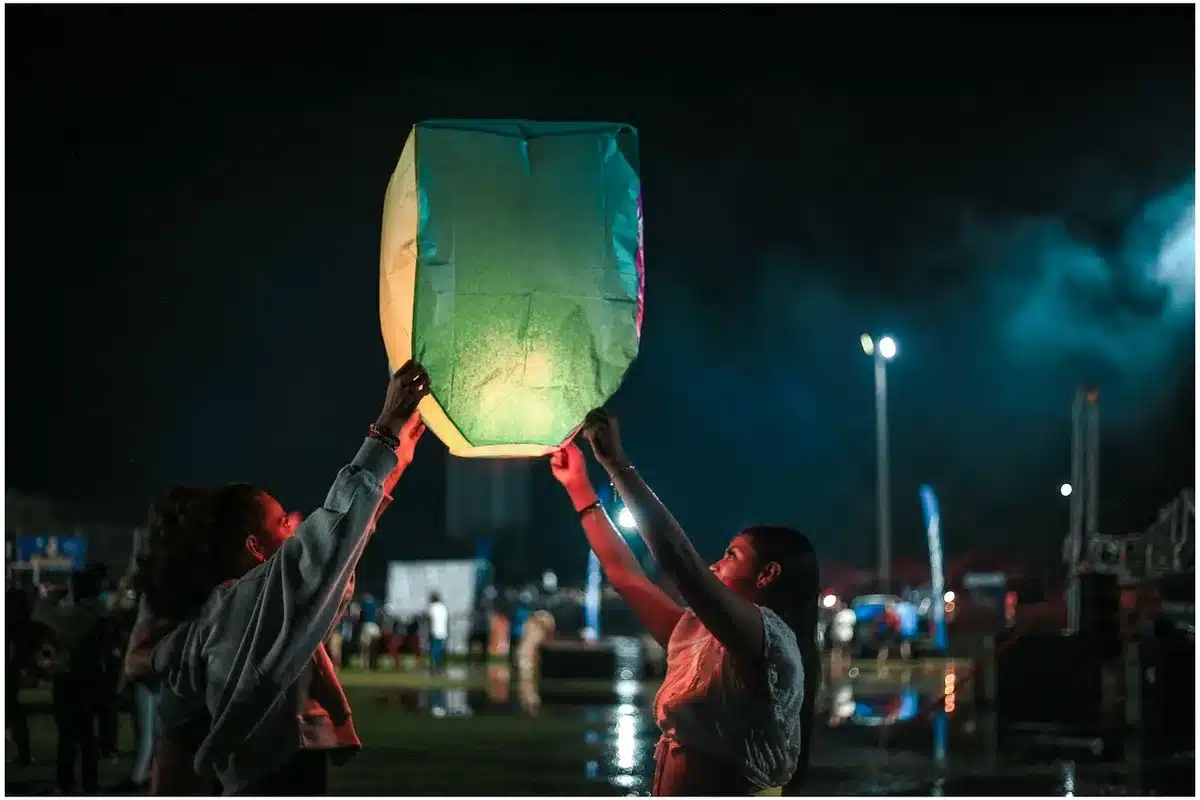 Folla anonima in piazza con lanterne a forma di pecora durante un festival serale