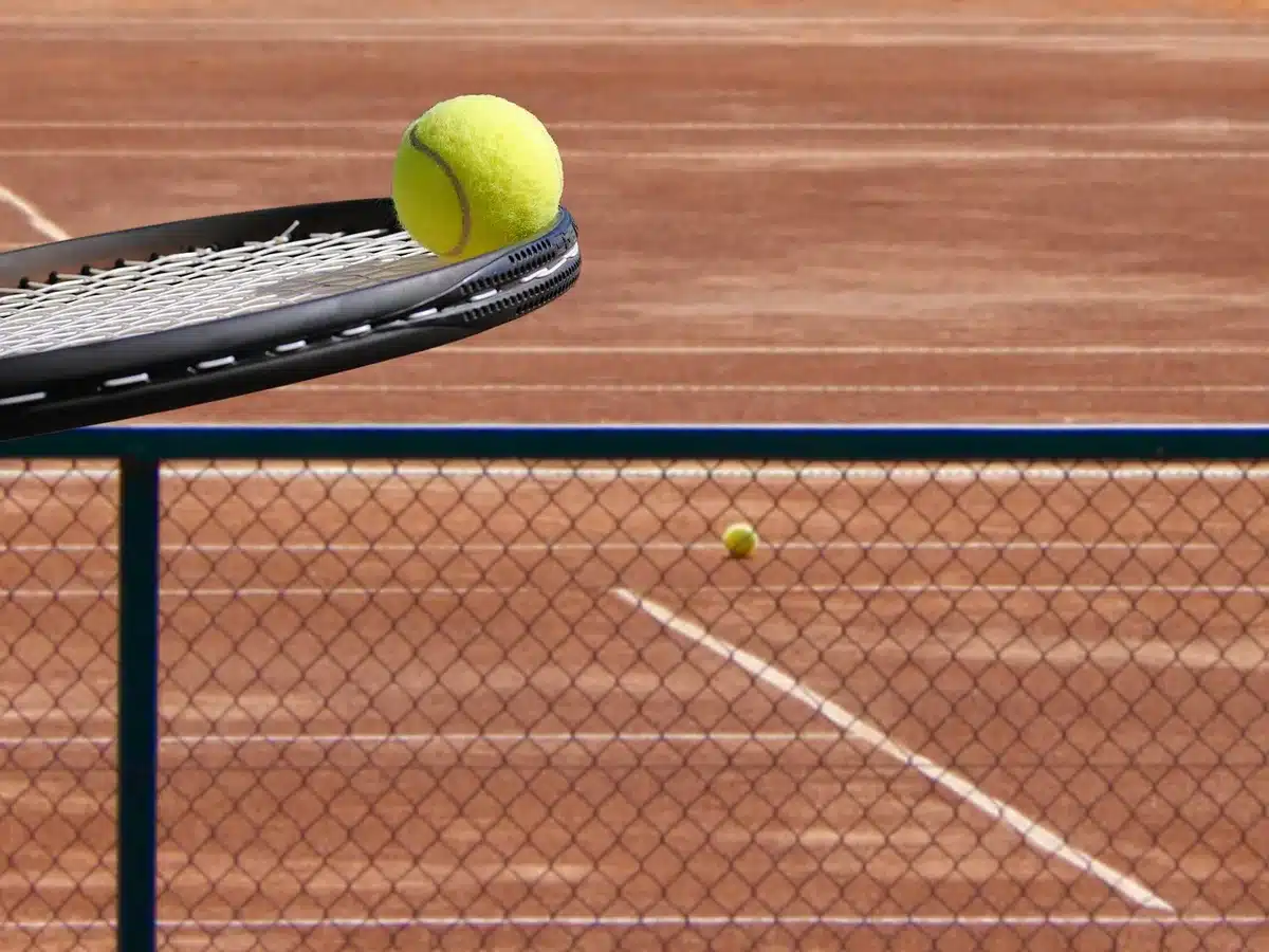 Campo da tennis vuoto con una racchetta abbandonata e buste di denaro sul fondo